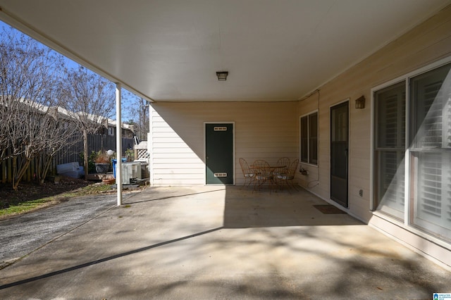 view of patio / terrace featuring outdoor dining area, an attached carport, and fence