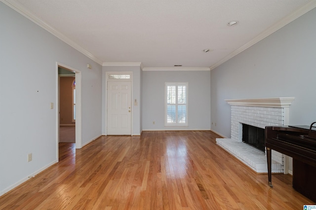 living area featuring a brick fireplace, light wood-type flooring, baseboards, and crown molding