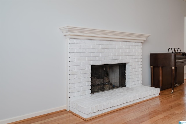 room details with a fireplace, baseboards, and wood finished floors