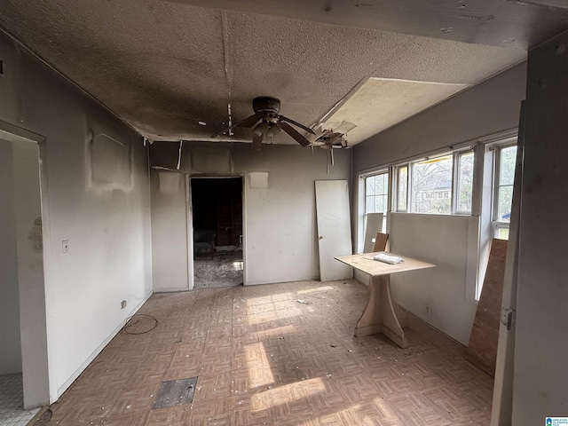 interior space with a textured ceiling and ceiling fan