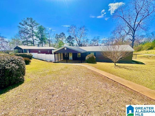 ranch-style home with a front yard and fence