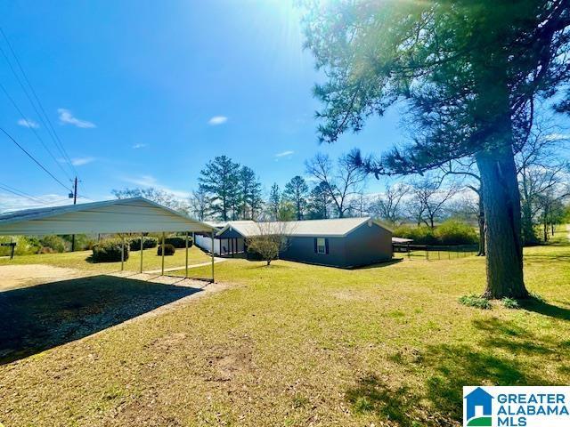 view of yard with a carport and driveway