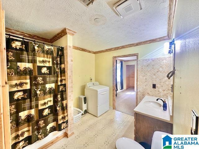 full bathroom featuring tile patterned floors, visible vents, washer / clothes dryer, and ornamental molding