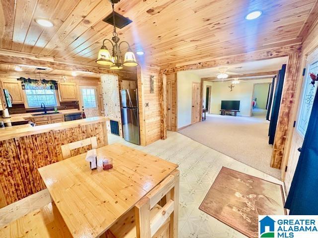 dining room featuring a chandelier and wooden ceiling