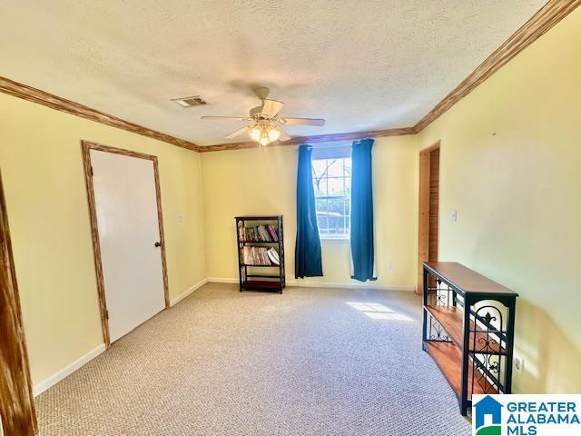 sitting room featuring visible vents, light carpet, a ceiling fan, a textured ceiling, and crown molding