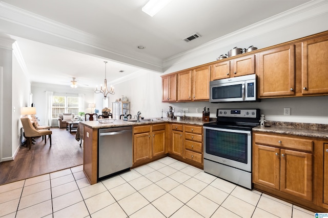 kitchen featuring visible vents, appliances with stainless steel finishes, a peninsula, light tile patterned flooring, and brown cabinetry