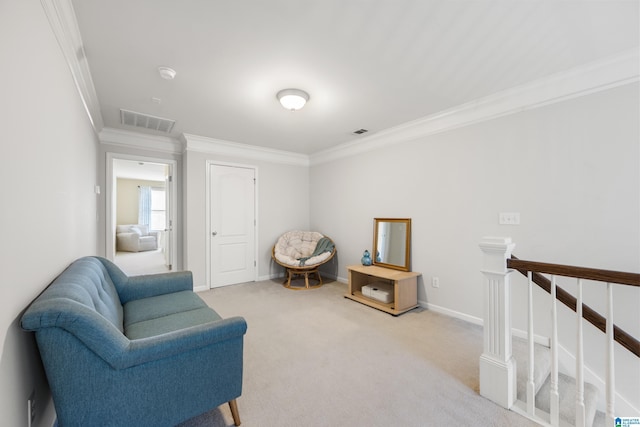 living area featuring baseboards, visible vents, carpet floors, and ornamental molding