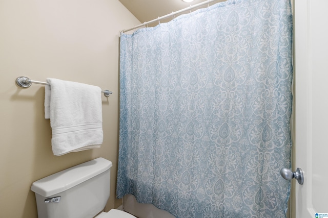 full bath with toilet and a shower with curtain