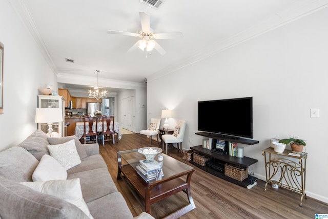 living area featuring visible vents, baseboards, ornamental molding, ceiling fan with notable chandelier, and wood finished floors