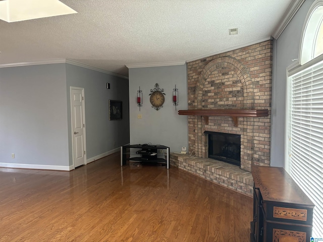 unfurnished living room with a textured ceiling, wood finished floors, a fireplace, and crown molding