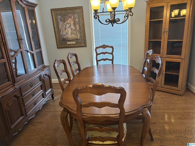 dining area with baseboards, dark wood-type flooring, and a notable chandelier