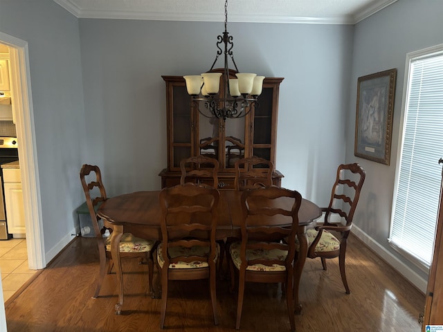 dining room with baseboards, wood finished floors, and ornamental molding