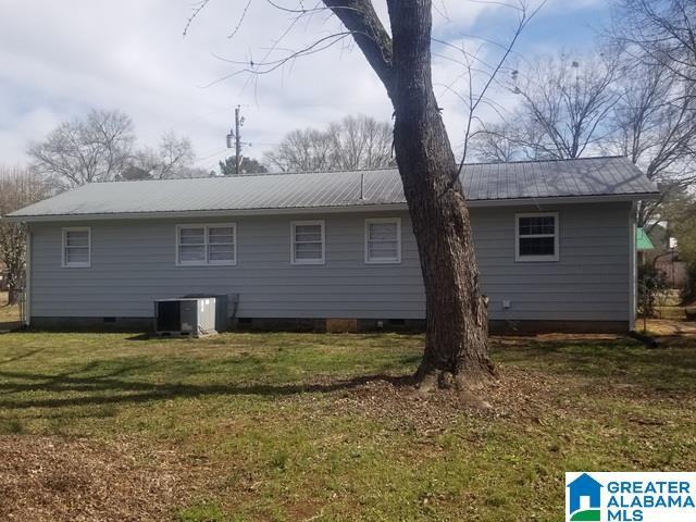 back of house with metal roof, central AC unit, a lawn, and crawl space