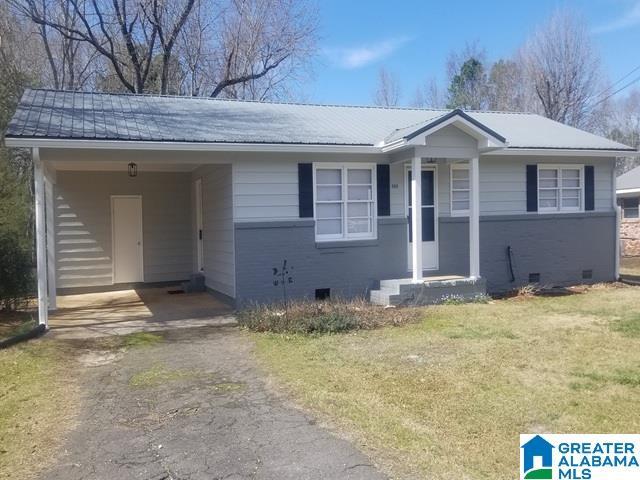 ranch-style home with brick siding, crawl space, an attached carport, and driveway