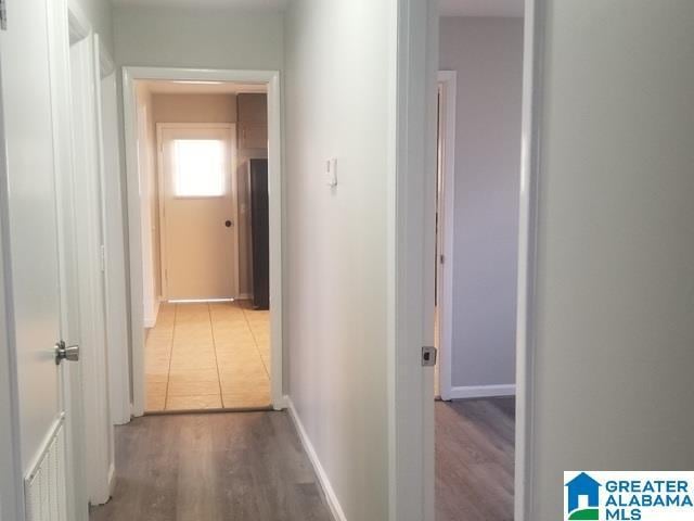 corridor with wood finished floors and baseboards