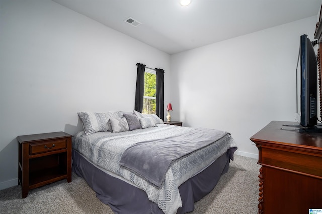 bedroom featuring light carpet, visible vents, and baseboards