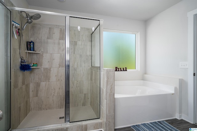 bathroom with a stall shower and a garden tub