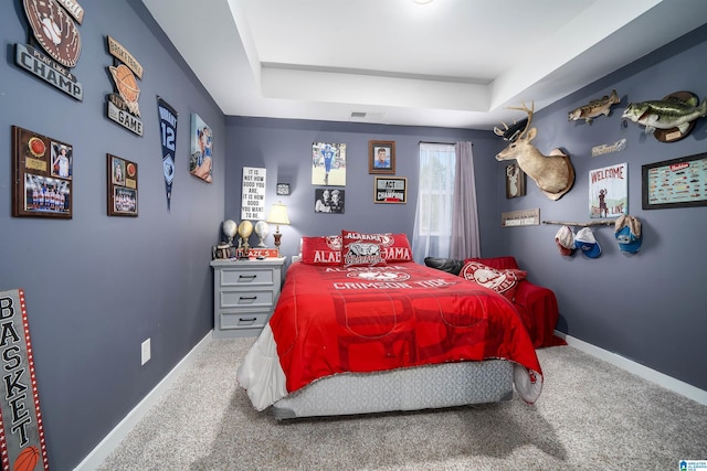 bedroom with visible vents, a raised ceiling, baseboards, and carpet floors