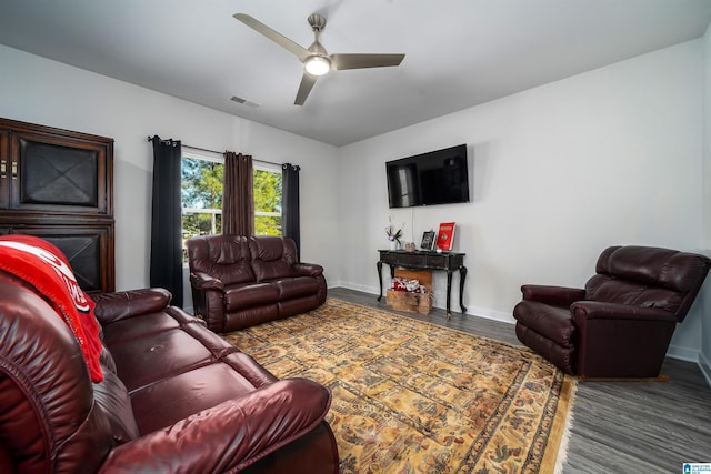 living room with visible vents, baseboards, wood finished floors, and a ceiling fan