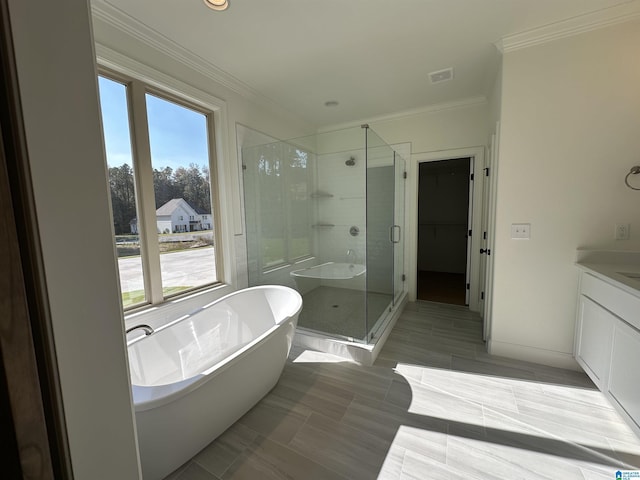 full bath featuring vanity, baseboards, a stall shower, a freestanding bath, and ornamental molding