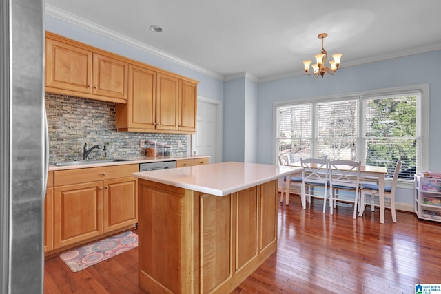 kitchen featuring a chandelier, ornamental molding, hardwood / wood-style floors, and a sink