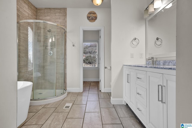 full bath featuring a shower stall, baseboards, a freestanding bath, tile patterned floors, and vanity