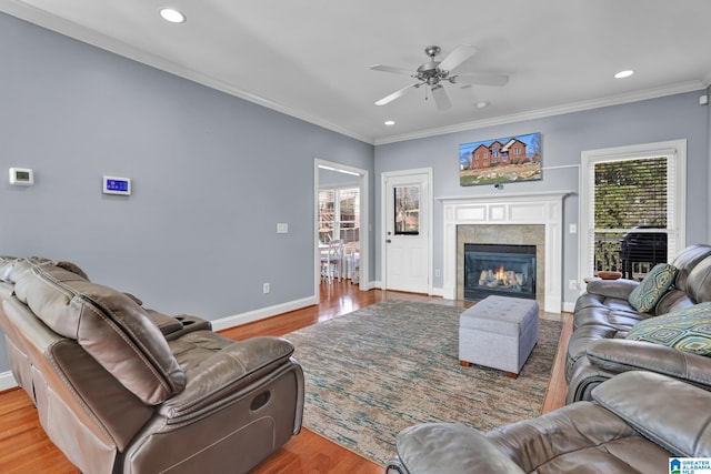 living area featuring a ceiling fan, wood finished floors, recessed lighting, crown molding, and baseboards