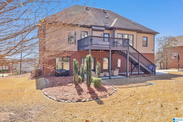 rear view of house featuring brick siding, stairway, a yard, a deck, and a patio area