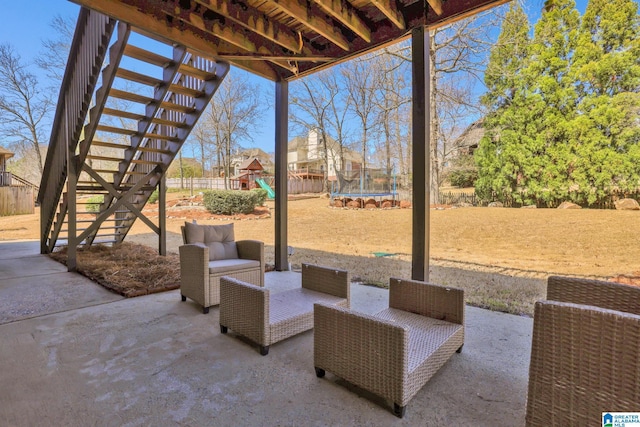 view of patio / terrace with stairway, a playground, a trampoline, and fence