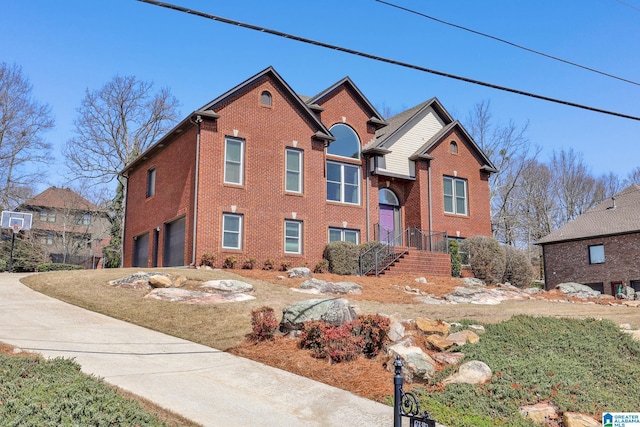 view of front of house with driveway, brick siding, and an attached garage