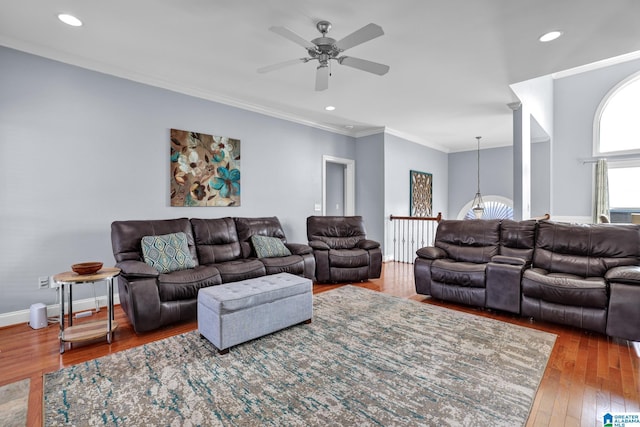 living area featuring ceiling fan with notable chandelier, hardwood / wood-style floors, recessed lighting, crown molding, and baseboards