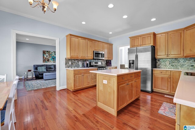 kitchen with a kitchen island, a chandelier, light countertops, light wood-type flooring, and stainless steel appliances