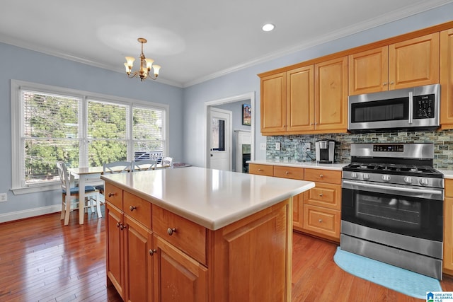 kitchen with light countertops, backsplash, appliances with stainless steel finishes, and a chandelier