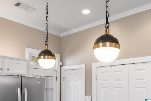 room details with hanging light fixtures, visible vents, freestanding refrigerator, and ornamental molding