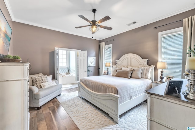 bedroom featuring light wood finished floors, visible vents, multiple windows, and crown molding