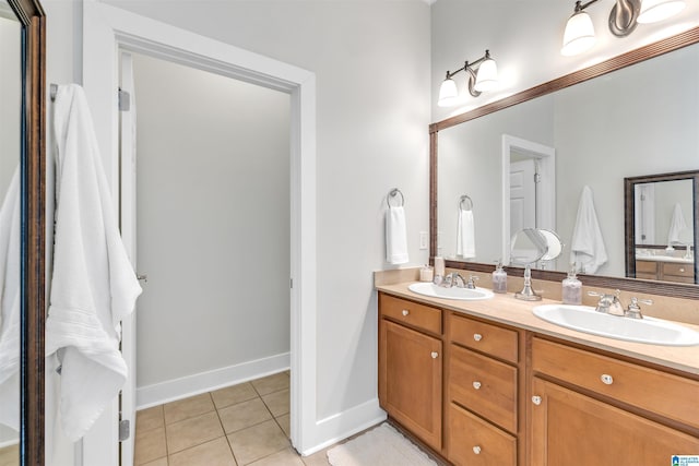 full bathroom featuring tile patterned flooring, double vanity, baseboards, and a sink