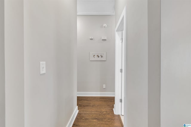 corridor with dark wood-style floors and baseboards