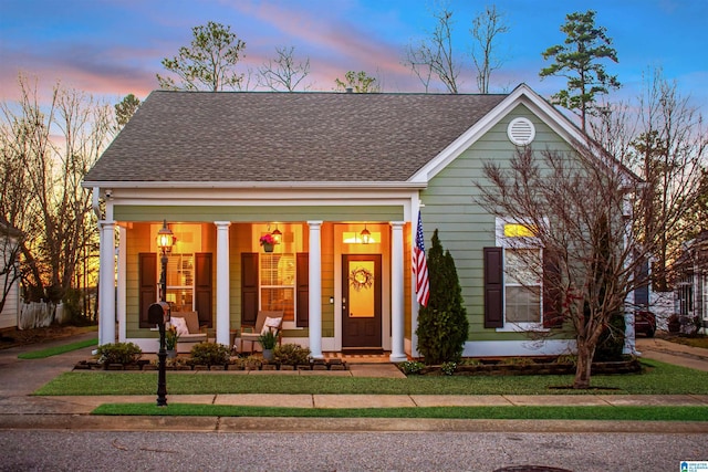 view of front of property featuring roof with shingles and a porch