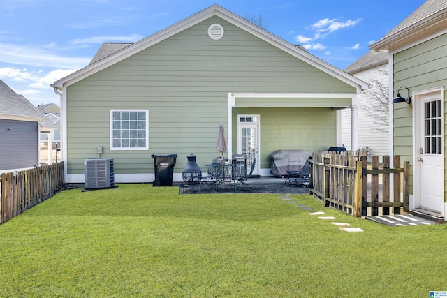 back of house with a yard, central AC unit, and fence