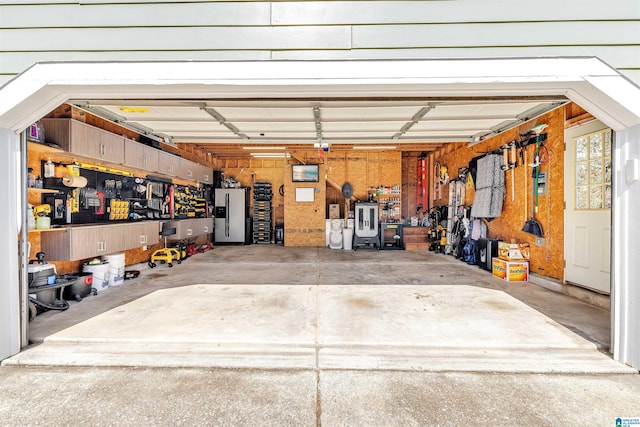 garage featuring stainless steel refrigerator with ice dispenser and driveway