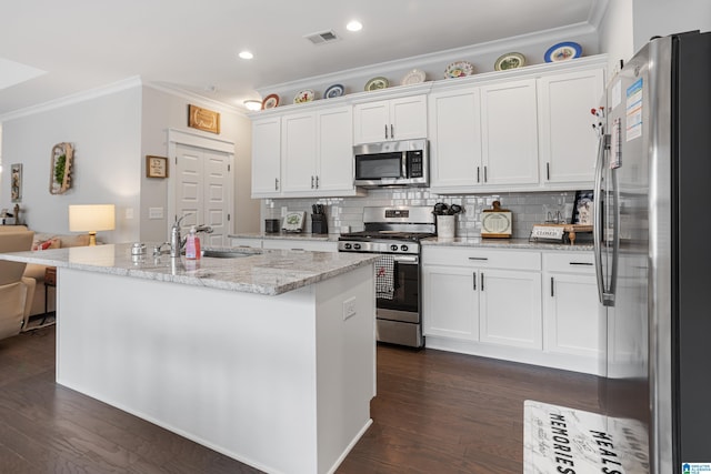 kitchen with ornamental molding, a sink, dark wood-type flooring, appliances with stainless steel finishes, and white cabinetry