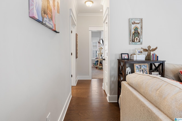 hallway with crown molding, baseboards, and dark wood-style flooring