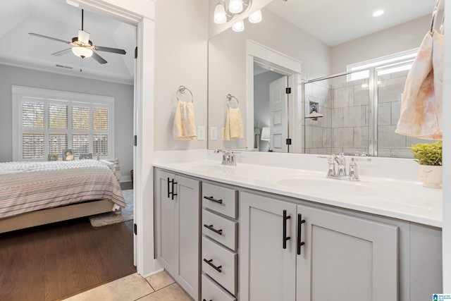 ensuite bathroom with double vanity, visible vents, a shower stall, and a sink