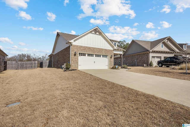 view of front of property with brick siding, board and batten siding, fence, a garage, and driveway