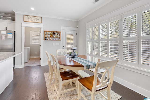 dining room featuring washing machine and clothes dryer, dark wood-style floors, baseboards, and ornamental molding