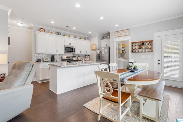 kitchen featuring decorative backsplash, appliances with stainless steel finishes, white cabinets, and dark wood-style flooring