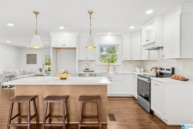 kitchen featuring visible vents, a sink, a kitchen island, dark wood-style floors, and electric range oven