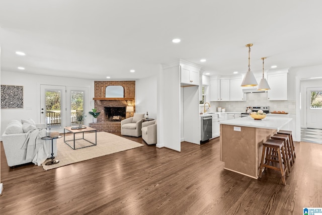 kitchen featuring stainless steel appliances, extractor fan, open floor plan, and light countertops