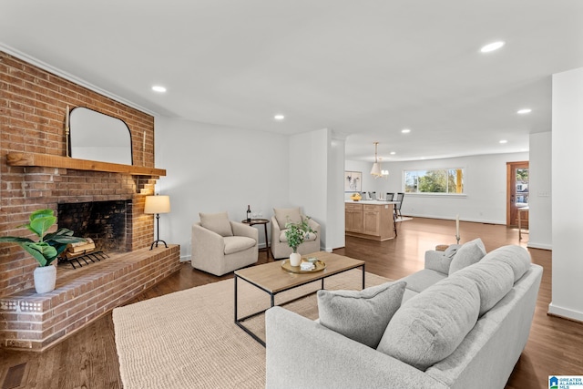 living room with visible vents, recessed lighting, a fireplace, baseboards, and dark wood-style flooring