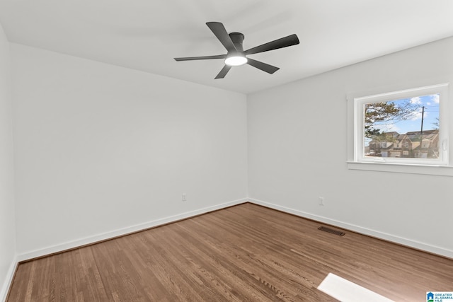 unfurnished room with visible vents, ceiling fan, baseboards, and wood finished floors